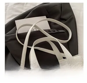 Détail d'un sac à main blanc motif litchi avec fermoir doré et bandoulière réglable