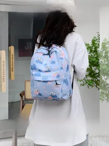 Détail d'un sac à dos bleu clair avec motifs de dinosaures, ours blancs et nuages