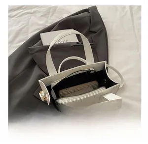 Détail du sac à main blanc à texture litchi montrant l'espace intérieur et le fermoir