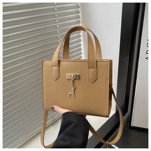 Détail du sac cabas en cuir grainé kaki avec breloques cerf dorées et boucles en métal