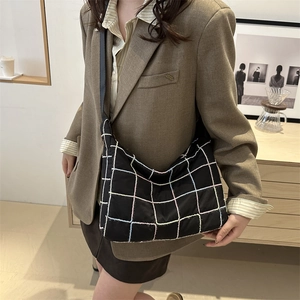 Black checkered large capacity tote bag with colorful stitching shown on a model