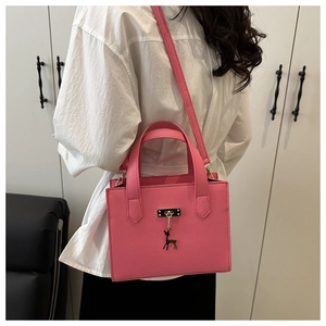 Sac carré rose en cuir grainé avec pendentif cerf doré et bandoulière amovible