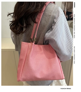 Detail of pink woven tote bag with striped texture and golden metal ring handle connector
