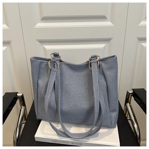 Close-up of blue twill fabric tote bag with elegant gold metal ring strap connectors