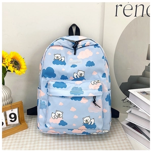 Détail du sac à dos dinosaure bleu clair avec motifs ours polaire et écusson mode