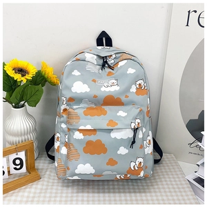 Détail du sac à dos dinosaure avec motifs d'ours et étiquette de mode tissée