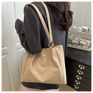 Detail view of beige canvas tote bag with metal rings shown in modern interior setting