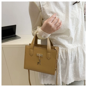 Détail du sac en cuir grainé avec pendentif cerf doré et fine bandoulière réglable