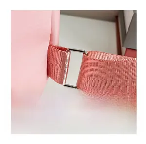 Close-up of pink nylon shoulder strap with a silver metal buckle on a large backpack