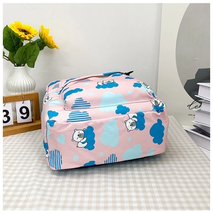 Détail du sac à dos dinosaure rose avec motifs d'ours mignons et de nuages