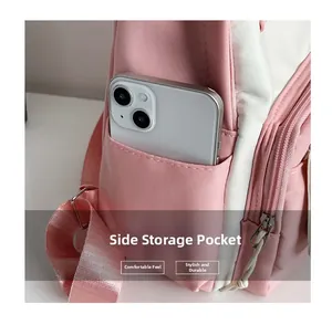 Detail view of a side storage pocket on a pink and white backpack with a smartphone inside