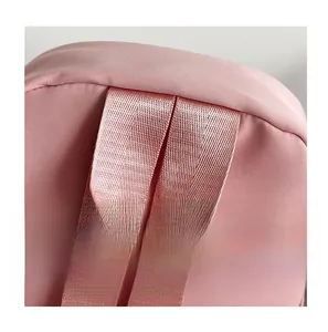 Close-up of durable pink nylon webbing handle on a minimalist large capacity backpack