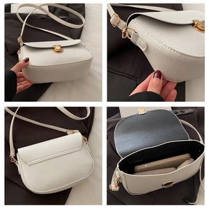 Detail view of white lychee leather saddle bag with gold hardware and interior capacity