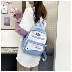 Detail view of the blue and white canvas backpack featuring a fashion sport embroidered logo