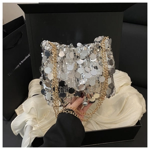 Detail of silver sequin crossbody bag with gold chain strap in premium gift packaging