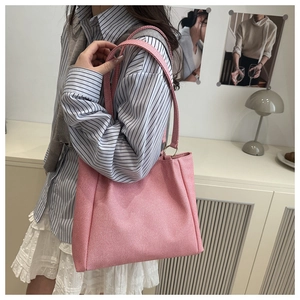 Side view of pink canvas shoulder bag showing fabric texture and dual handles
