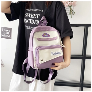 Detail of a purple and white color-blocked backpack with fashion logo patches