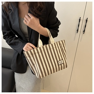 Close-up of brown and white striped canvas tote with Camping label and cotton straps