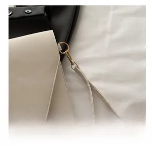 Détails du sac à main enveloppe beige avec cuir texturé et garniture en métal doré