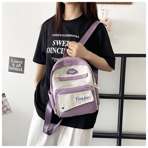 Detail of a purple and white contrast backpack featuring front embroidery and side pockets