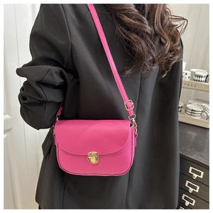 Detail of fuchsia saddle bag showing high-quality lychee texture and gold metal clasp