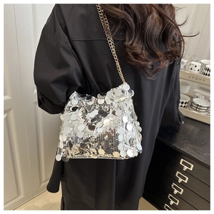 Close-up of sparkling silver sequins and golden chain strap on a stylish evening bag
