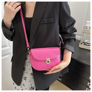 Detail of rose pink saddle bag with lychee texture and golden metal buckle clasp