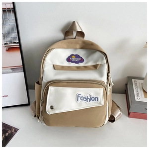Detail of contrast-color backpack featuring Fashion embroidery and front zipper pocket