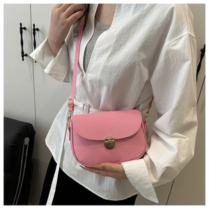 Detail of pink pebble leather shoulder bag with round golden twist lock and adjustable strap