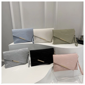 Detail of multi-color minimalist envelope clutch bags with unique pleated texture and gold bar