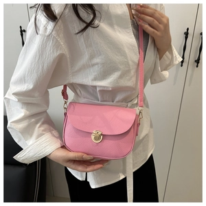 Detail of pink saddle bag with lychee leather texture and golden metal buckle