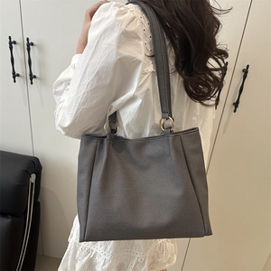 Minimalist charcoal grey tote bag with gold metal rings and spacious canvas structure