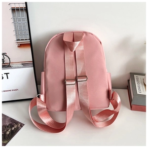 Rear view of pink nylon backpack featuring adjustable shoulder straps and side pockets