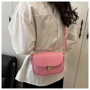 Pink lychee grain leather saddle bag shown on model for a side-back crossbody view