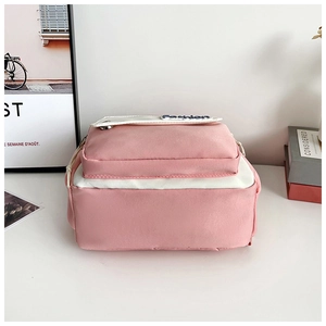 Detail of pink and white nylon backpack with Fashion patch and front pocket
