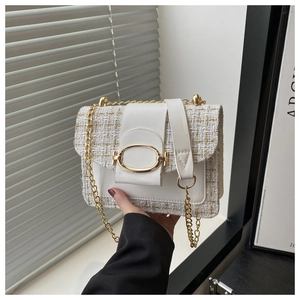 Détail du sac à bandoulière en tweed blanc avec chaîne dorée et boucle métallique