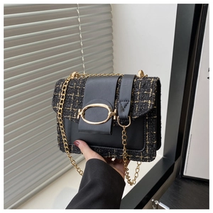 Détail du sac bandoulière en tweed noir et doré avec fermoir métallique et chaîne
