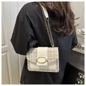 Détail du sac bandoulière en tweed beige avec chaîne dorée et fermoir métallique chic