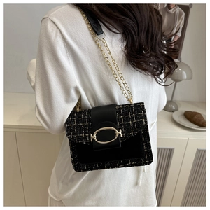 Détail du sac bandoulière en tweed noir et doré avec fermoir et chaîne métallique