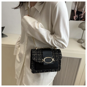 Détail du sac bandoulière en tweed noir avec boucle en métal doré et bandoulière chaîne