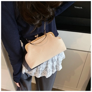 Détail du sac tressé abricot clair avec fermoir rétro doré et bandoulière chaîne