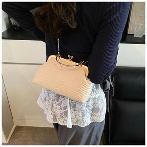 Détail du sac beige tissé en forme de coquillage avec fermoir doré et bandoulière