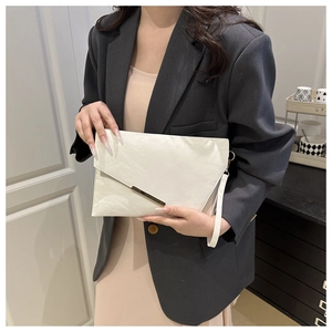 Détail d'une pochette enveloppe blanche avec texture marbre et bordure en métal doré