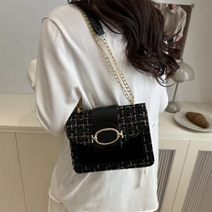 Sac bandoulière élégant en tweed noir avec chaîne dorée porté par un mannequin