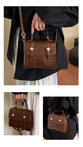 Detail of vintage brown satchel with metallic star decor and embossed lettering