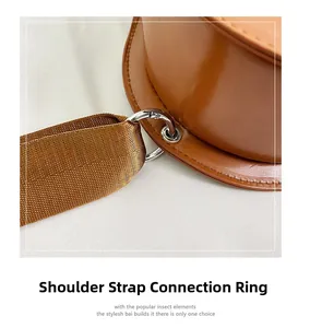 Detail of guitar shaped bag with silver metal D-ring and brown textile shoulder strap