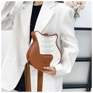 Detail view of guitar shaped crossbody bag featuring metallic studs and contrast color design