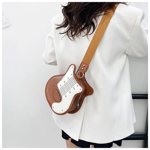 Detail of creative violin-shaped crossbody bag with guitar motif and metal rivets