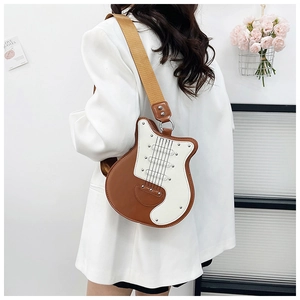 Detail of guitar-shaped crossbody bag with rivet accents and wide yellow fabric strap