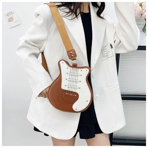 Detail of guitar-shaped crossbody bag with brown faux leather and wide strap